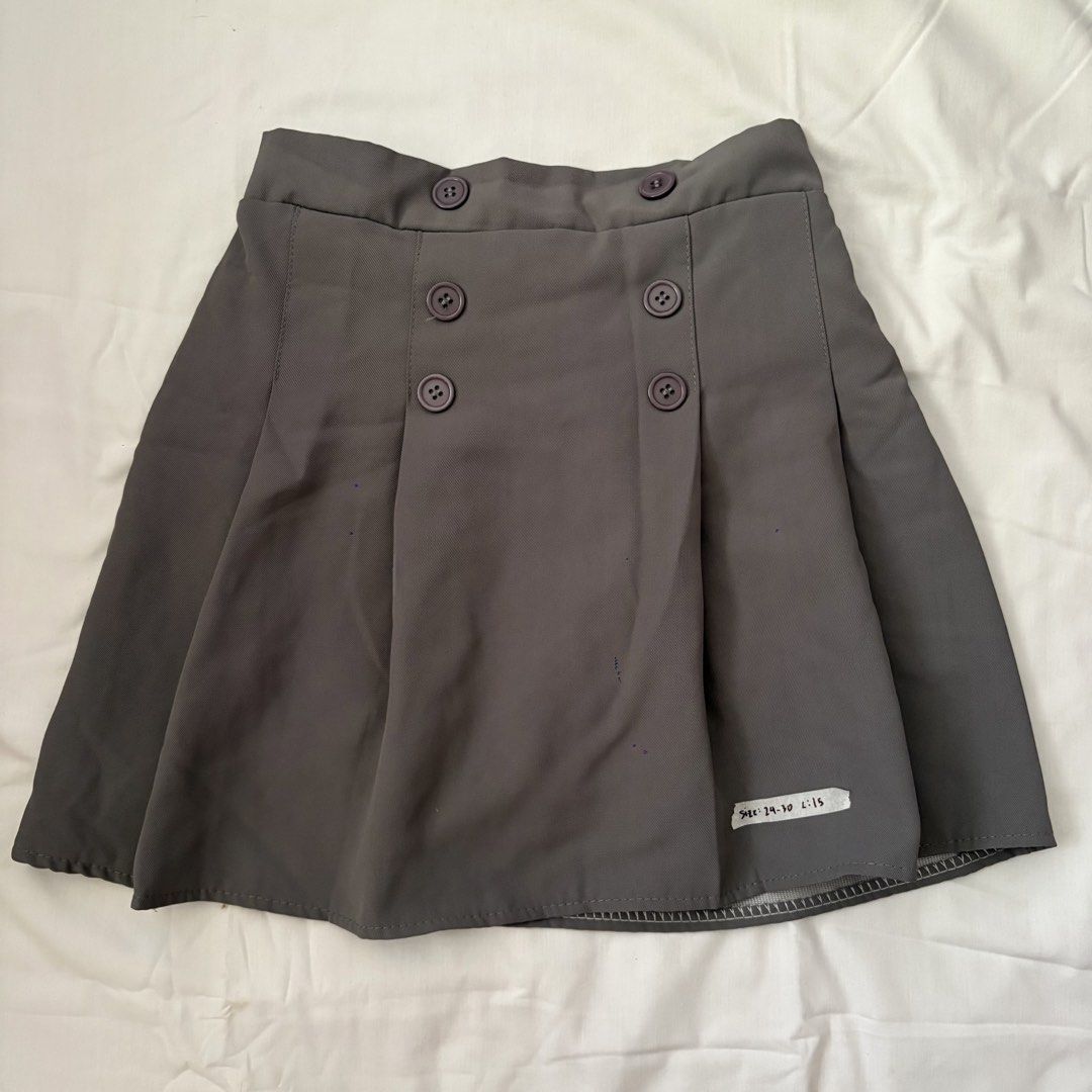 Grey Double-Breasted Pleated Skirt with Buttons (Category: Skirts) located in Calabanga. Submitted by vrncashane (Listing ID 1468858751, Image 1). Description: - Color: Dark grey - Style: Pleated with stylish double-breasted front buttons - Fit: High waist cut, structured fabric - Size: 24-30 - Length: 15 inches - Condition: Clean, well-maintained piece - Great for: Casual days or preppy outfits.