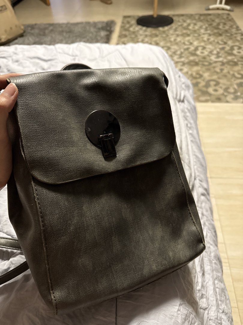 Leather Gray backpack (Category: Backpacks) located in Caloocan City. Submitted by tootsief (Listing ID 1468866490, Image 2). Description: - Material: Premium grey faux leather - Closure: Flap top with secure circular metal lock - Straps: Adjustable back straps and a convenient top handle - Interior: Clean, fully lined compartment with a zipper closure and extra pockets - Capacity: Roomy enough to hold all your daily essentials.