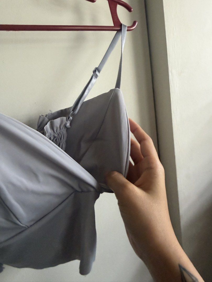 Grey/Light Blue V-neck Padded Cropped Top (Category: Sleeveless) located in Dasmarinas. Submitted by maikee0417 (Listing ID 1468761898, Image 2). Description: - Style: V-neck wrap front cami crop top - Color: Grey / Blue-ish - Features: Built-in padding (no bra needed), adjustable thin straps, and a super stretchy smocked back panel - Condition: Worn a few times, still in great shape RFS: no longer use.