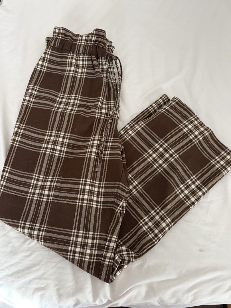 GU Brown Plaid Drawstring Trousers (Category: Trousers) located in Las Pinas. Submitted by thriftedfinds_ (Listing ID 1468829287, Image 2). Description: - Brand/Style: GU brown and white plaid pants - Fit: High-waisted with straight leg cut - Waistband: Elastic with adjustable drawstring tie - Material: 66% polyester, 32% rayon, 2% polyurethane with smooth inner lining - Versatility: Great for casual wear or dressing up.