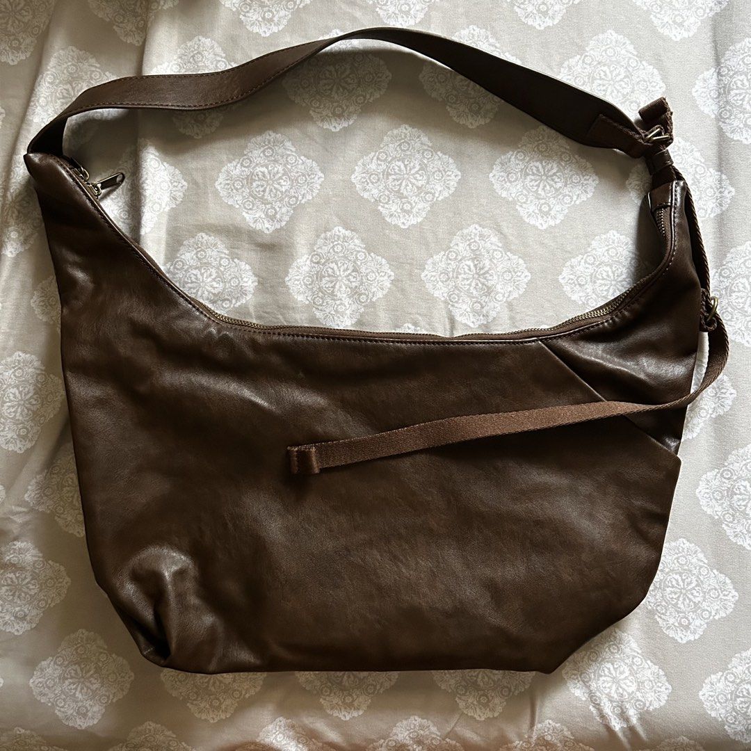 GU Brown shoulder bag (Category: Shoulder Bags) located in Marikina City. Submitted by ellies.mnl (Listing ID 1468754946, Image 1). Description: - Color & Material: Rich brown faux leather - Style: Slouchy hobo silhouette with a clean, minimalist look - Closure: Secure zip-top closure - Adjustability: Adjustable strap for a customized drop length - Structure: Flat structured bottom panel to maintain shape - Versatility: Ideal for casual outfits a