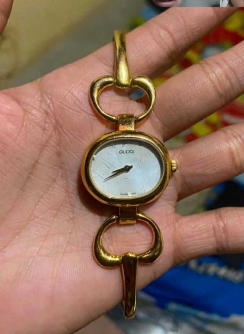 Gucci 1800 Gold Bangle Watch (Category: Luxury Watches) located in Manila. Submitted by preloved119 (Listing ID 1468821324, Image 2). Description: - Authentic vintage Gucci women's watch - Model: 1800 (with engraved serial number and crest on case back) - Movement: Reliable battery-operated quartz - Design: Elegant gold-tone metal with bangle-style bracelet and clasp closure - Dial: Oval white face featuring the classic Gucci logo - Condition: Mi