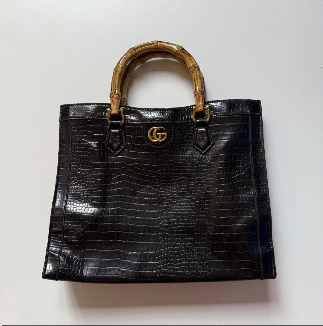 Gucci Dianna silhouette bag (Category: Luxury Bags & Wallets) located in Bacolod. Submitted by lux.antithrifts (Listing ID 1468765670, Image 1). Description: Materials: Crafted from black crocodile-embossed leather paired with distinctive, expertly curved natural bamboo top handles. Hardware: Features gold-tone hardware, including the signature Double G metal logo anchored on the upper center front. Design & Structure: A structured rectangular to