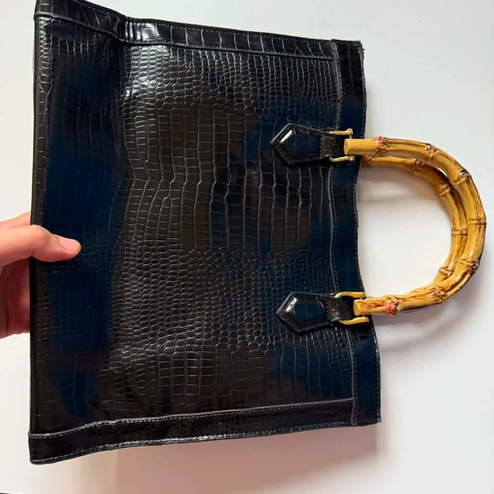 Gucci Dianna silhouette bag (Category: Luxury Bags & Wallets) located in Bacolod. Submitted by lux.antithrifts (Listing ID 1468765670, Image 3). Description: Materials: Crafted from black crocodile-embossed leather paired with distinctive, expertly curved natural bamboo top handles. Hardware: Features gold-tone hardware, including the signature Double G metal logo anchored on the upper center front. Design & Structure: A structured rectangular to