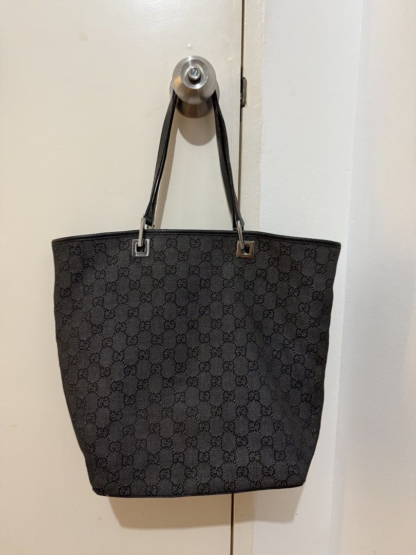 Gucci Monogram Black Denim Tote Bag (Category: Tote Bags) located in Manila. Submitted by calmpenguin.043b6a (Listing ID 1468750973, Image 1). Description: - Brand: Gucci - Style: Denim GG Monogram Tote - Color: Black denim with black leather trim - Hardware: Silver-tone with engraved Gucci lettering - Interior: Black fabric lining with zippered pocket, leather brand tag, and serial number - Dimensions: Approx. 14" height - Condition: Clean overa