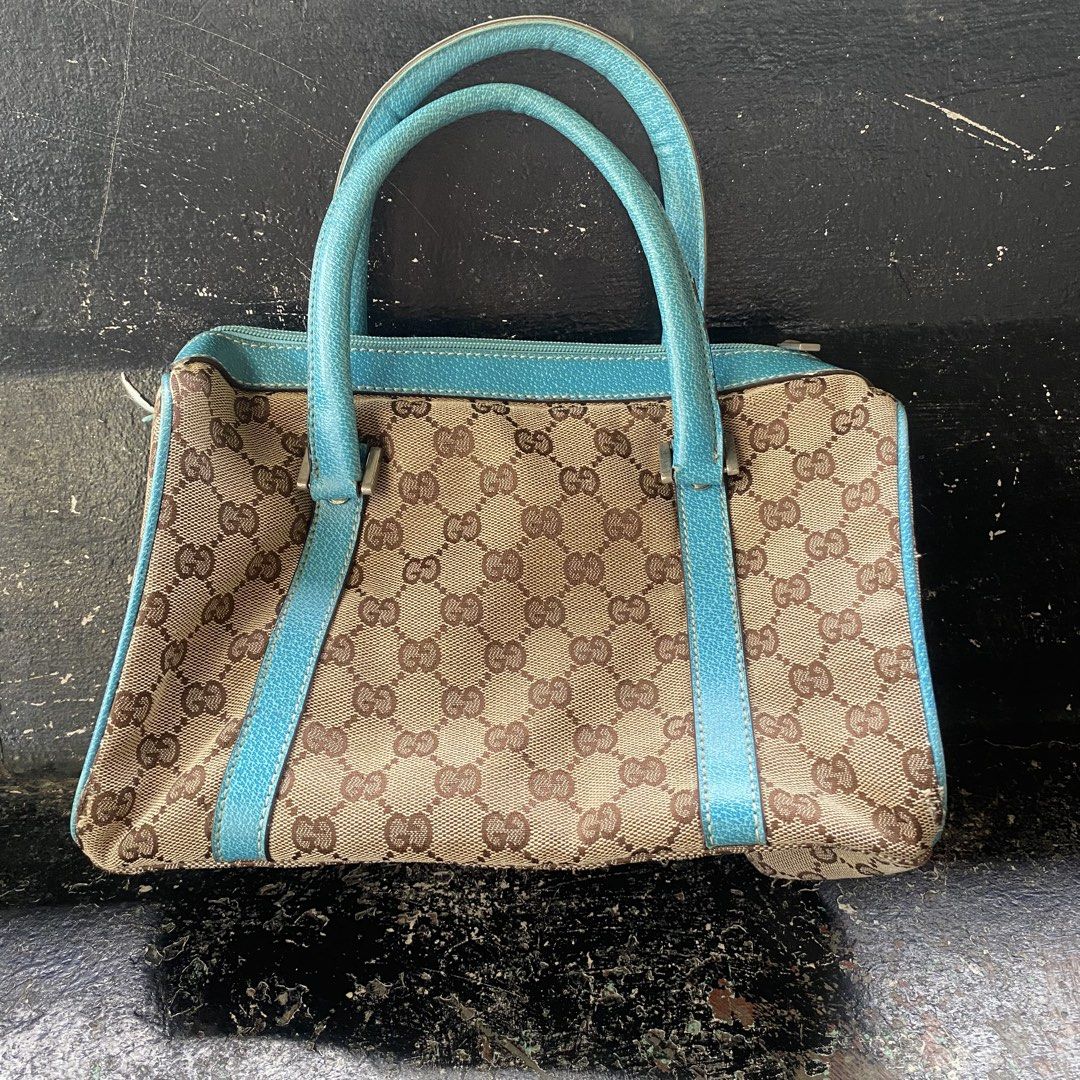 Gucci Monogram Canvas Blue Trim Handbag (Category: Luxury Bags & Wallets) located in Manila. Submitted by 5treetw3ar (Listing ID 1468767136, Image 1). Description: - Brand: Gucci - Material: Classic brown monogram canvas with bright blue leather trim - Hardware: Silver-toned - Closure: Top zipper - Handles: Dual top handles - Structure: Compact silhouette with a flat base (stands upright easily) - Interior: Clean fabric lining - Condition: Excell