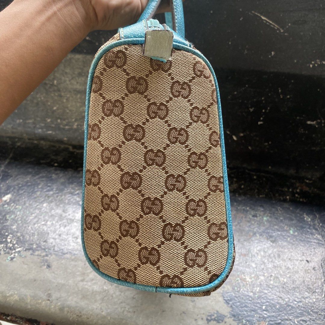 Gucci Monogram Canvas Blue Trim Handbag (Category: Luxury Bags & Wallets) located in Manila. Submitted by 5treetw3ar (Listing ID 1468767136, Image 3). Description: - Brand: Gucci - Material: Classic brown monogram canvas with bright blue leather trim - Hardware: Silver-toned - Closure: Top zipper - Handles: Dual top handles - Structure: Compact silhouette with a flat base (stands upright easily) - Interior: Clean fabric lining - Condition: Excell