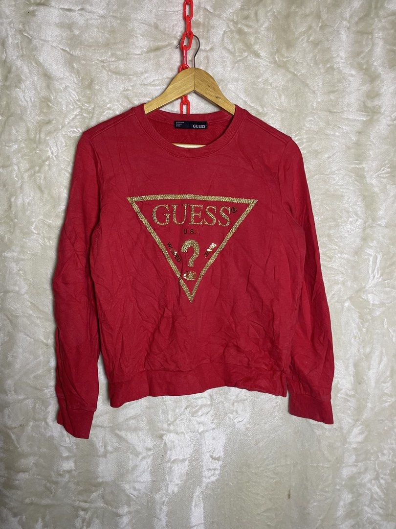Guess Red Sweatshirt with Gold Glitter Logo (Category: Coats, Jackets and Outerwear) located in Molave. Submitted by charlesthrifter (Listing ID 1468860620, Image 1). Description: - Color: Bright red - Design: Large triangular Guess U.S.A. logo in gold glitter - Style: Classic pullover crewneck with long sleeves - Details: Ribbed cuffs and hem for a snug fit - Condition: Excellent, no stains or damage, ready to wear.