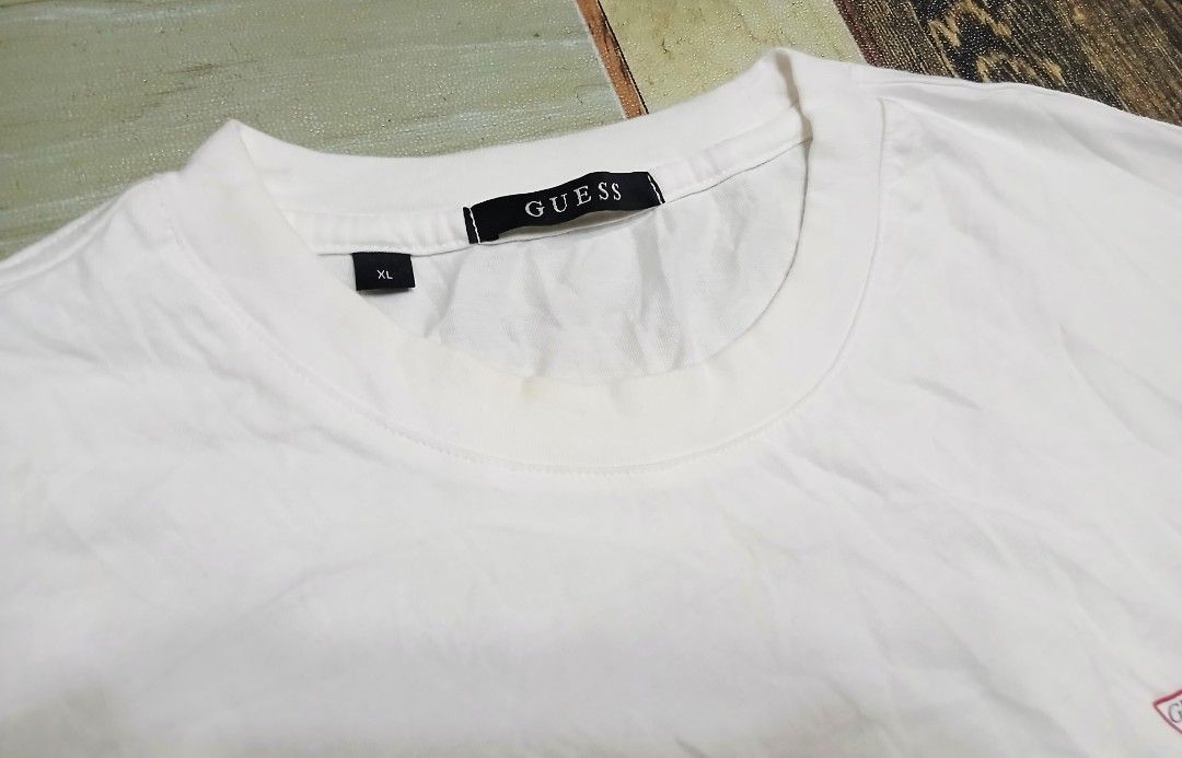 Guess White Tee Shirt XL (Category: Activewear) located in Caloocan City. Submitted by youngmoon_51e2c6 (Listing ID 1468793790, Image 3). Description: - Brand: Guess - Color: Plain White - Size: XL - Material: 100% Cotton - Features: Small red triangle logo on left chest, classic crew neck, lightweight regular fit - Style No.: NP2K9480 - Condition: Clean overall, great for daily casual wear.
