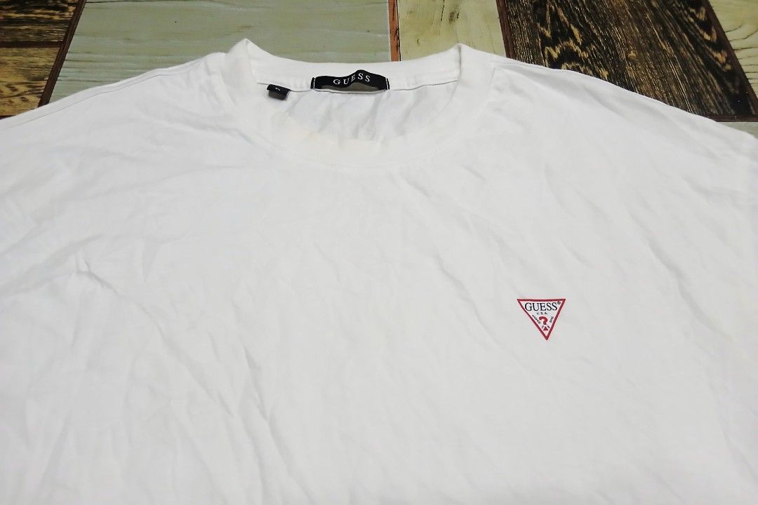 Guess White Tee Shirt XL (Category: Activewear) located in Caloocan City. Submitted by youngmoon_51e2c6 (Listing ID 1468793790, Image 2). Description: - Brand: Guess - Color: Plain White - Size: XL - Material: 100% Cotton - Features: Small red triangle logo on left chest, classic crew neck, lightweight regular fit - Style No.: NP2K9480 - Condition: Clean overall, great for daily casual wear.