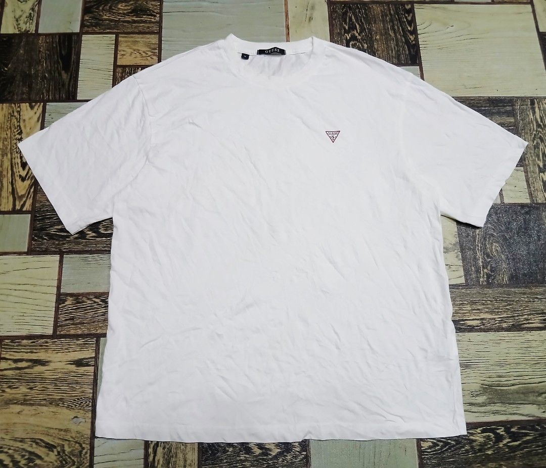 Guess White Tee Shirt XL (Category: Activewear) located in Caloocan City. Submitted by youngmoon_51e2c6 (Listing ID 1468793790, Image 1). Description: - Brand: Guess - Color: Plain White - Size: XL - Material: 100% Cotton - Features: Small red triangle logo on left chest, classic crew neck, lightweight regular fit - Style No.: NP2K9480 - Condition: Clean overall, great for daily casual wear.