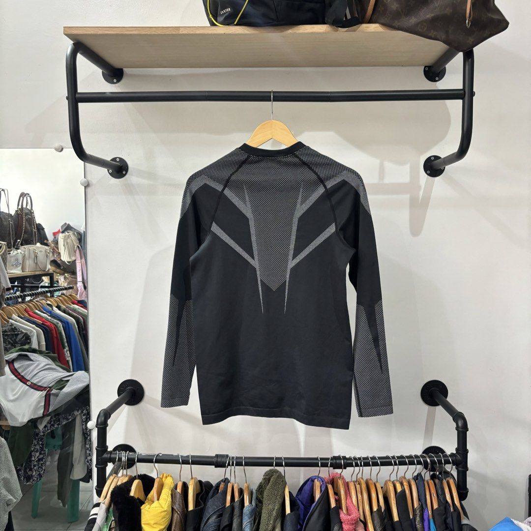 Gymshark Black Grey Long Sleeve Compression Shirt (Category: Activewear) located in Bambang. Submitted by heats777 (Listing ID 1468821994, Image 3). Description: - Brand: Gymshark - Color: Black and grey - Details: Mesh texture on chest, upper back, and sleeves - Branding: White Gymshark logo on chest and 'BEAVISIONARY' print on the inside elastic hem - Condition: Slight loose thread on the inner collar binding, otherwise great.
