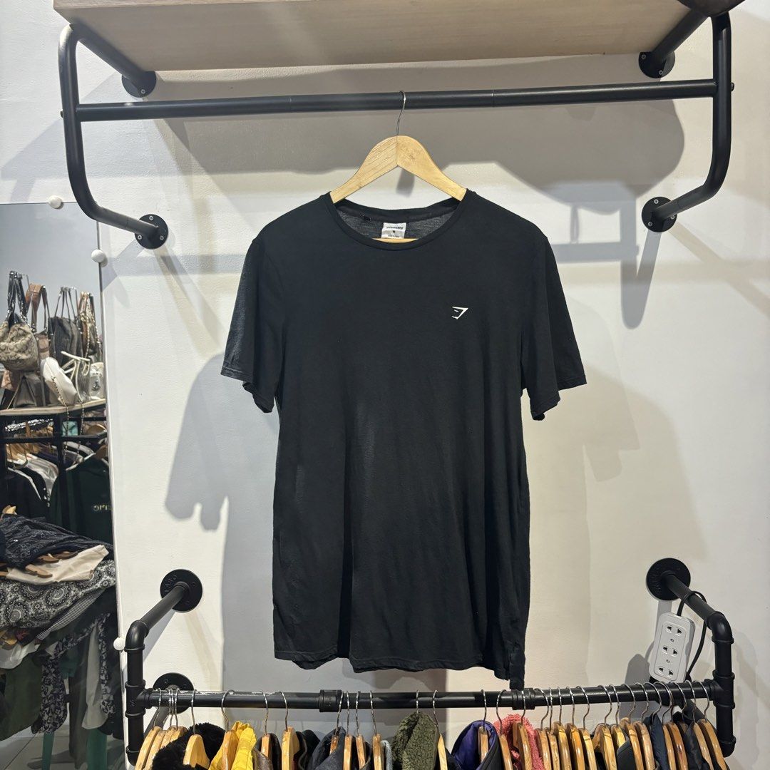 Gymshark Black T-Shirt Size M (Category: Tshirts & Polo Shirts ) located in Bambang. Submitted by heats777 (Listing ID 1468840683, Image 2). Description: - Brand: Gymshark - Color: Black - Size: Medium - Fit: Standard fit (great for gym or casual wear) - Design: Crew neck, short sleeves, small logo on left chest - Material: Polyester, cotton, and viscose blend - Origin: Made in China.