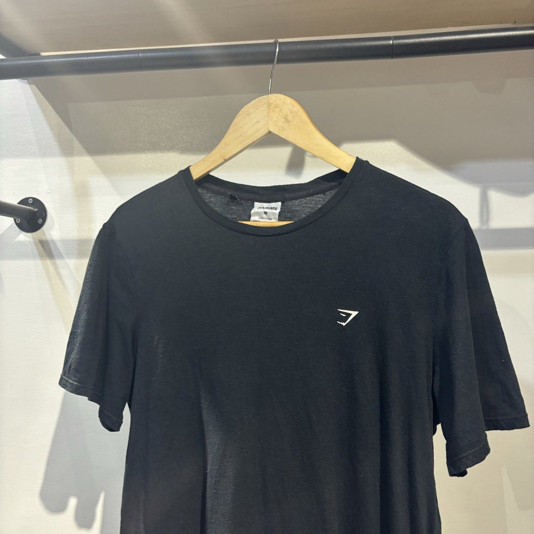 Gymshark Black T-Shirt Size M (Category: Tshirts & Polo Shirts ) located in Bambang. Submitted by heats777 (Listing ID 1468840683, Image 1). Description: - Brand: Gymshark - Color: Black - Size: Medium - Fit: Standard fit (great for gym or casual wear) - Design: Crew neck, short sleeves, small logo on left chest - Material: Polyester, cotton, and viscose blend - Origin: Made in China.