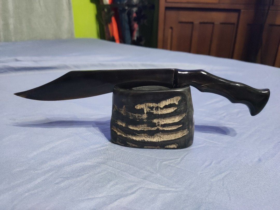 Handcrafted decorative horn dagger with stand (Category: Vintage Collectibles) located in Santa Maria. Submitted by bexsantiago (Listing ID 1468808962, Image 3). Description: - Unique decorative dagger crafted from genuine animal horn - Dark blade and handle with a sleek, polished finish - Includes a matching textured display stand made of horn - Solid build with smooth, elegant contours - Perfect statement piece for desks, shelves, or weapon col