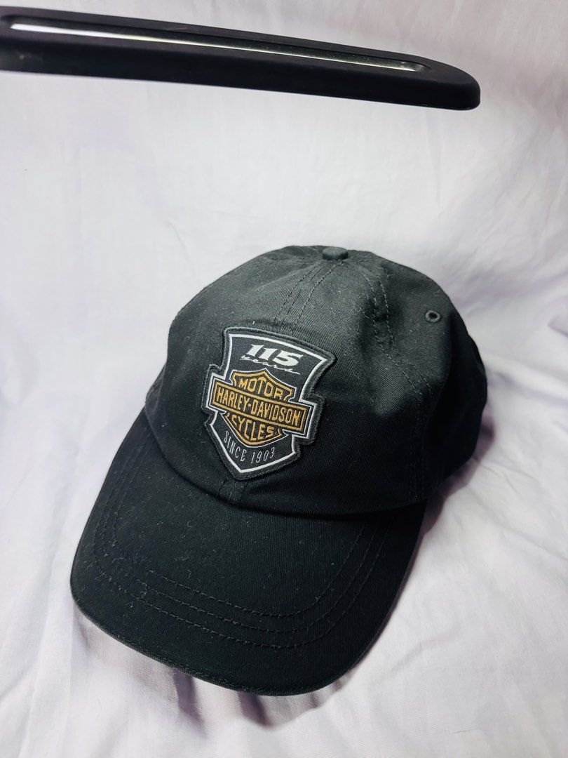 Harley Davidson 115 Years Black Baseball Cap (Category: Caps & Hats) located in Roxas City. Submitted by patsquarephantz (Listing ID 1468858039, Image 1). Description: - Official Harley-Davidson 115th Anniversary commemorative baseball cap - Classic black color with detailed embroidered front patch (115 Years & Since 1903) - Genuine Motor Clothes interior tag guaranteeing authenticity - Adjustable back strap with a durable metal clasp for a custo