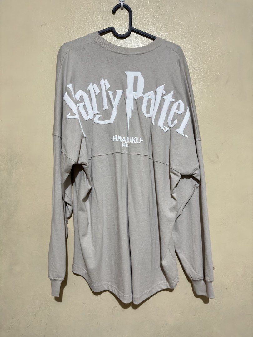 Harry Potter Spirit Jersey (Category: Coats, Jackets and Outerwear) located in Quezon City. Submitted by dragonlily_07251820 (Listing ID 1468806842, Image 2). Description: - Item: Harry Potter Wizarding World Spirit Jersey (bought from Harajuku, Japan) - Condition: Brand new with tag and original packaging card, unused - Color: Light grey with long sleeves and ribbed cuffs - Design: Bold white puff print lettering across the back shoulders - Deta