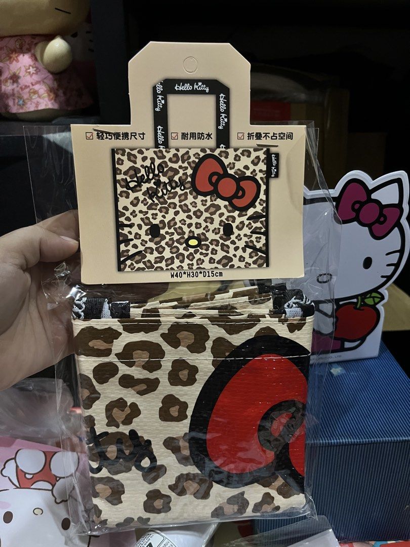 Hello Kitty Leopard Print Reusable Shopping Bag (Category: Tote Bags) located in Manila. Submitted by janetecson05 (Listing ID 1468929133, Image 1). Description: - Brand: Kitty - Design: Brown and black leopard print with signature red bow - Condition: Brand new, still sealed in original packaging - Dimensions: 40 x 30 x 15 cm - Material: Durable and waterproof - Feature: Folds down flat for easy storage.
