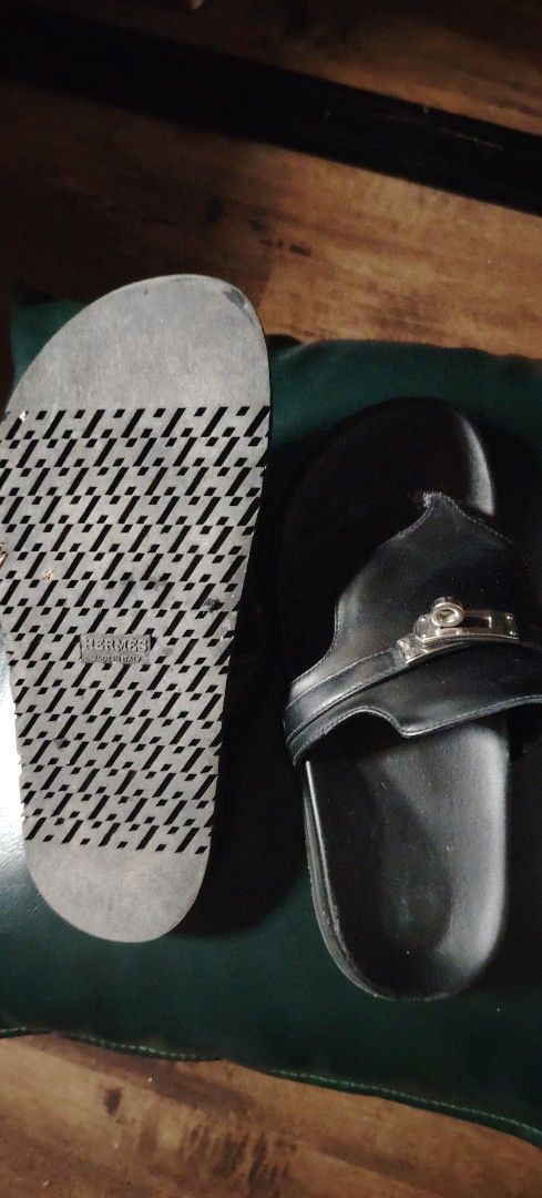 Hermes Black Leather Sandals With Kelly Hardware (Category: Flats & Sandals) located in Makati City. Submitted by cess2377 (Listing ID 1468808973, Image 2). Description: - Brand: Hermes - Style: Black leather thong sandals with slip-on design - Hardware: Iconic Kelly-style hardware engraved with "Hermes Paris" - Comfort: Cushioned footbed for all-day wear - Details: Signature patterned sole with Hermes and "Made in Italy" stamps - Condition: Sign
