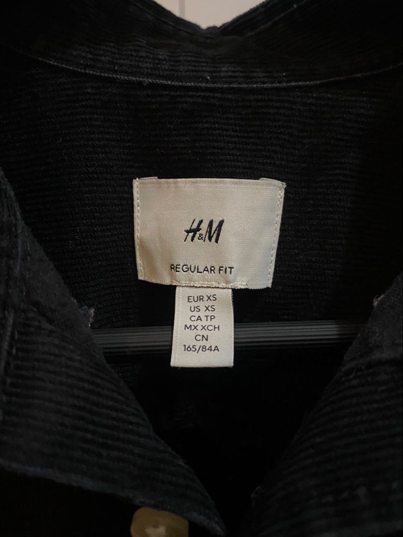 H&M CORDUROY SHIRT (Category: Tshirts & Polo Shirts ) located in Manila. Submitted by declutterlord (Listing ID 1468914084, Image 2). Description: Brand: H&M - Color: Black - Size: XS (Regular Fit) - Dimensions: 19.5in x 27in Notes: - ZERO bleach stains - ZERO puncture holes - ZERO loose buttons - CONSISTENT corduroy line pattern with no breaks or tears - NEGLIGIBLE fading (9.8/10) along the inner collar that is hardly noticeable when worn. - NEV