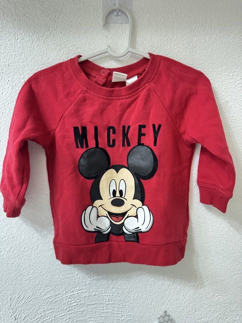 H&M Disney Mickey Mouse Red Sweatshirt 6-9M (Category: Babies & Kids Fashion) located in Manila. Submitted by janelica220598 (Listing ID 1468820968, Image 1). Description: - Brand: H&M - Design: Red Mickey Mouse graphic with bold black lettering - Size: 6-9 months (EUR 74) - Material: Soft cotton blend, ideal for cooler weather - Feature: Shoulder snap buttons for easy dressing - Condition: Clean and well-maintained.