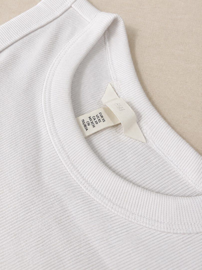 H&M White Ribbed Tank Top Size XS (Category: Sleeveless) located in Manila. Submitted by lexiandco.ph (Listing ID 1468722342, Image 3). Description: - Brand: H&M - Item: White ribbed tank top - Size: XS (True to size) - Material: Soft, stretchy cotton-blend - Design: Classic crew neckline, sleeveless - Condition: Excellent/Like new - Versatility: Great for layering or everyday wear.