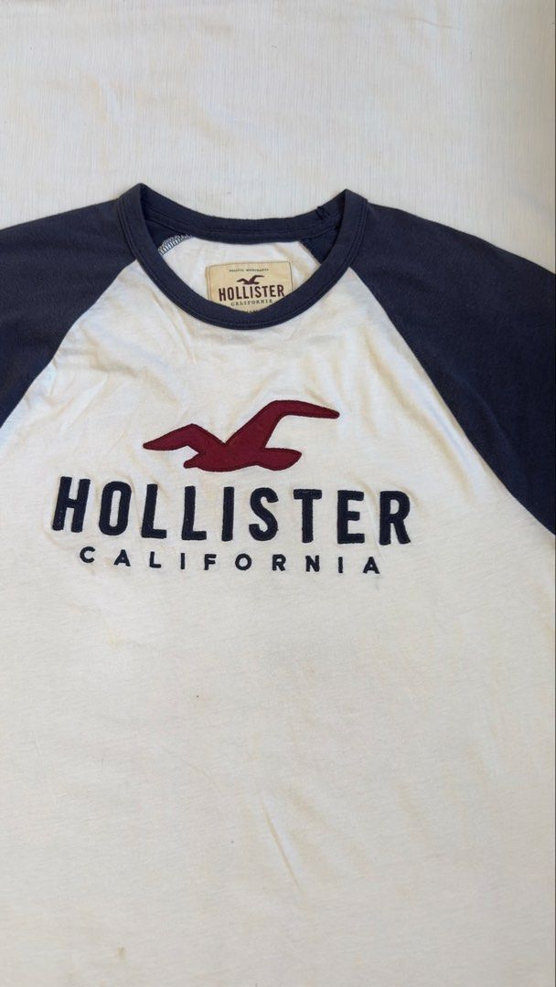 HOLLISTER SHRT (Category: Tshirts & Polo Shirts ) located in Davao. Submitted by kelsocool (Listing ID 1468799994, Image 2). Description: Hollister Two-Tone Raglan Graphic Tee Size: S Dimes (inch): 27 - length 20 - width 8 - sleeve color rate: 8.5/10 good condition issue - stain front marks Description: Classic Hollister California two-tone short-sleeve raglan tee in cream and navy blue with bold front seagull logo print..