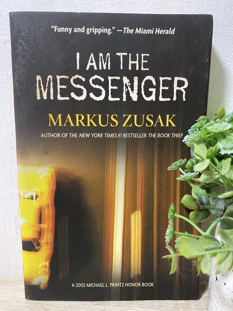 I Am The Messenger by Markus Zusak (Category: Storybooks) located in Quezon City. Submitted by cidrisse (Listing ID 1468836467, Image 1). Description: - Title: I Am The Messenger - Author: Markus Zusak (author of The Book Thief) - Format: Paperback - Edition Highlights: Includes 2005 Michael L. Printz Honor Book badge and quotes from The Miami Herald - Design: Clean dark cover with striking yellow lettering - Condition: Pre-loved, well-maintained