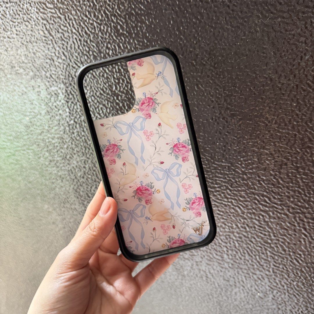 iphone 15 coquette phone case (Category: Cases & Sleeves) located in Manila. Submitted by coffeegilly (Listing ID 1468749152, Image 1). Description: coquette aesthetic with floral, blue ribbon, and bird pattern clear back with elegant pink roses and blue bows, paired with a sleek black frame.