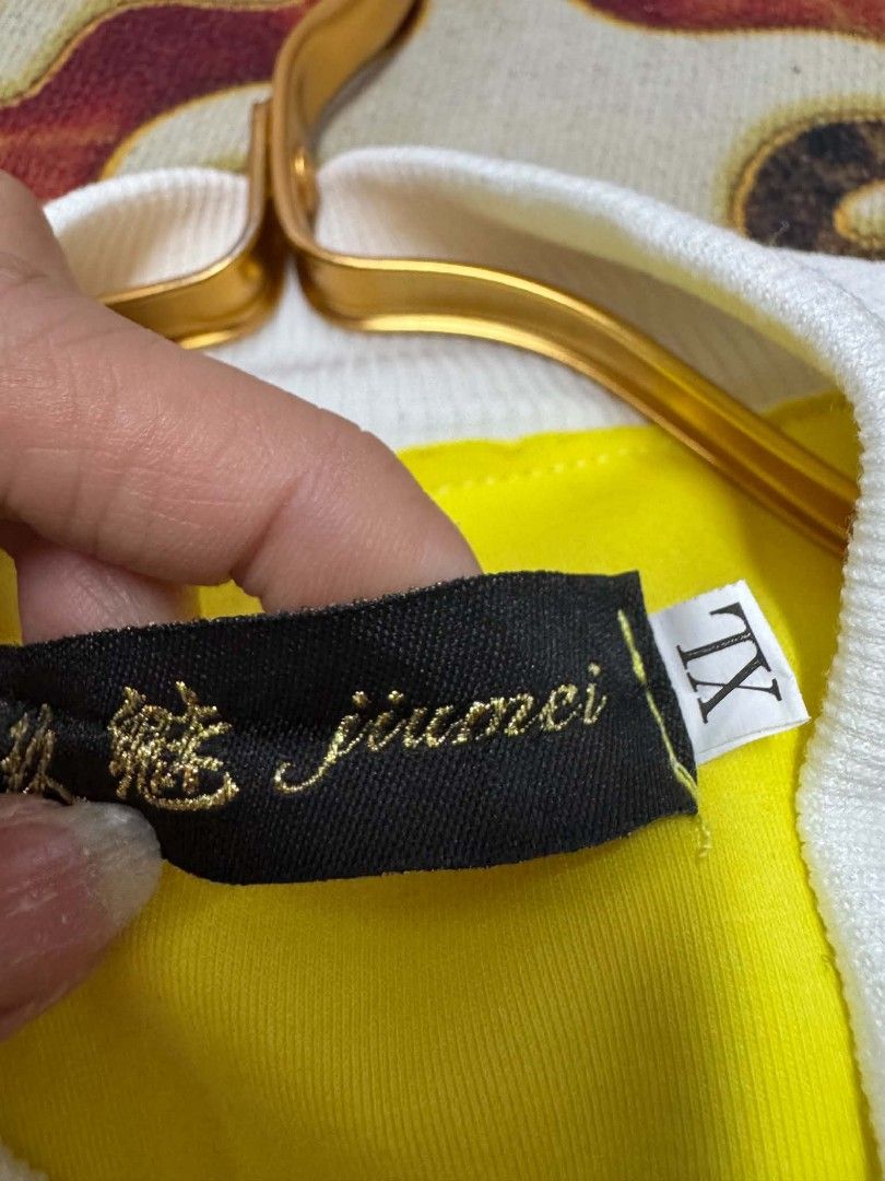 Jiumei Yellow White Bomber Jacket Size XL (Category: Coats, Jackets and Outerwear) located in Caloocan City. Submitted by mylove326 (Listing ID 1468803294, Image 3). Description: - Brand: Jiumei - Size: XL (Laid-flat length: approx. 23 inches) - Color: Bright yellow with white ribbed collar, cuffs, and hem - Design: Unique asymmetric button front closure and shoulder epaulets - Condition: Great piece to make a statement outfit pop.