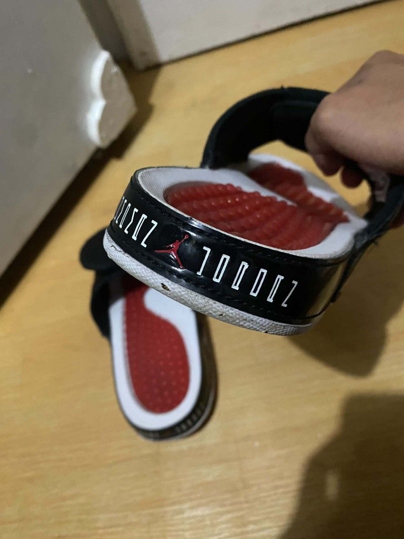 Jordan 11 Retro Bred Slide Sandals (Category: Slippers & Slides) located in Manila. Submitted by crlespino (Listing ID 1468832663, Image 2). Description: Black and red Jordan 11 Retro slides. Iconic Bred colorway with patent leather mudguard and number 23 branding. Red cushioned footbed with massage nubs. White midsole. Adjustable velcro strap on top. Comfortable slip-on sandals for casual wear..