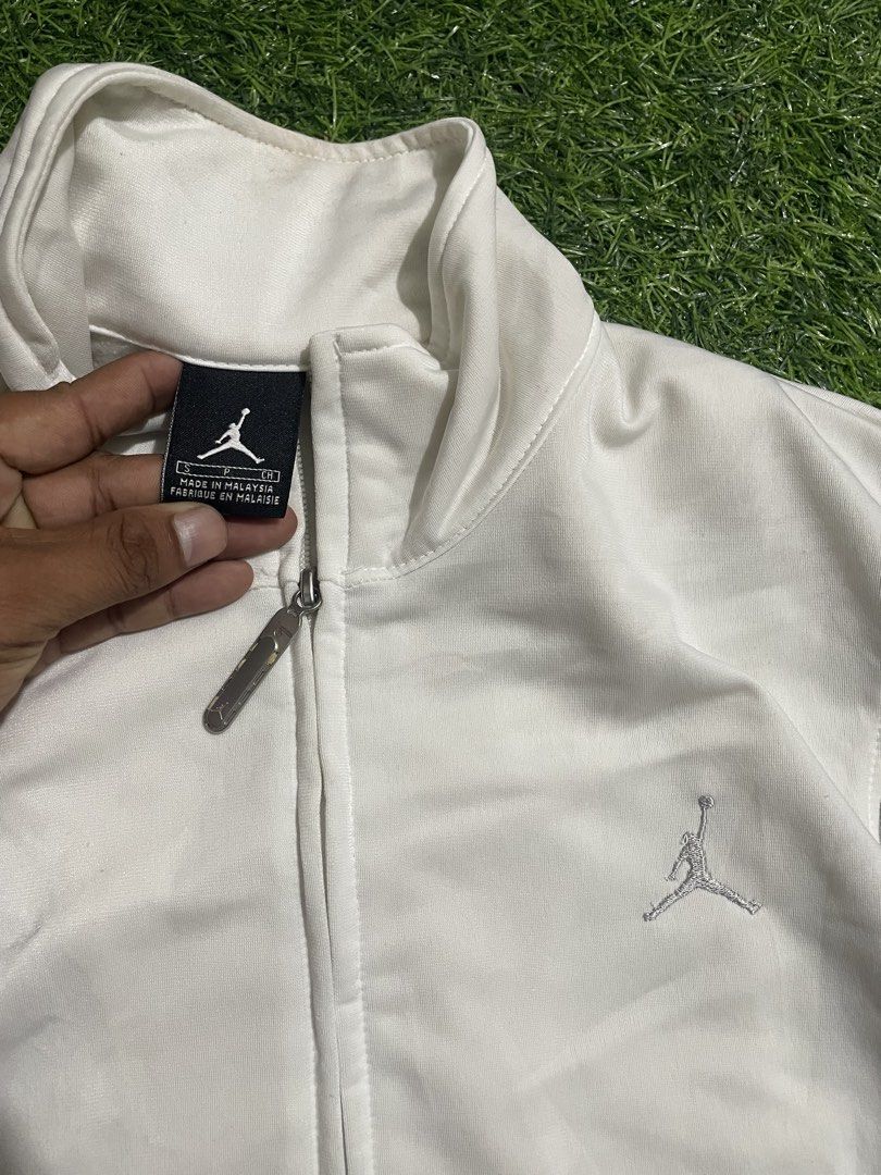 Jordan White and Grey Track Jacket Size S (Category: Coats, Jackets and Outerwear) located in Las Pinas. Submitted by jynxdefant26140 (Listing ID 1468900091, Image 2). Description: - Authentic Jordan track jacket - Color: White with grey panel accents - Size: Small - Made in Malaysia - Full zip closure with stand-up collar - Embroidered Jumpman logo on chest and small tag at hem - Ribbed cuffs for a comfortable fit - Condition: Excellent.