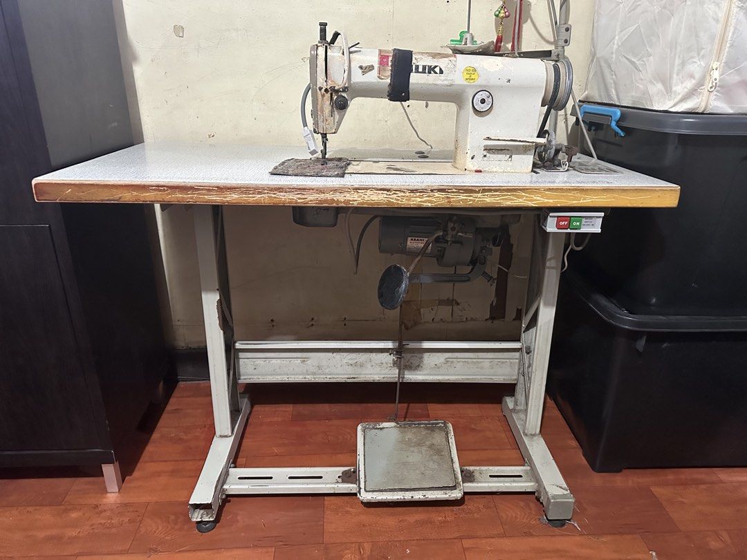 Juki Industrial Sewing Machine with Table and Motor (Category: Industrial Equipment) located in Pasay City. Submitted by kimverlygo50697 (Listing ID 1468792376, Image 2). Description: - Brand/Model: Juki heavy-duty industrial sewing machine - Setup: Mounted on a sturdy large wooden work table - Power: Integrated Asahi motor with foot pedal control and attached on/off switch box - Features: Built-in ruler along the table edge and spool holder stan