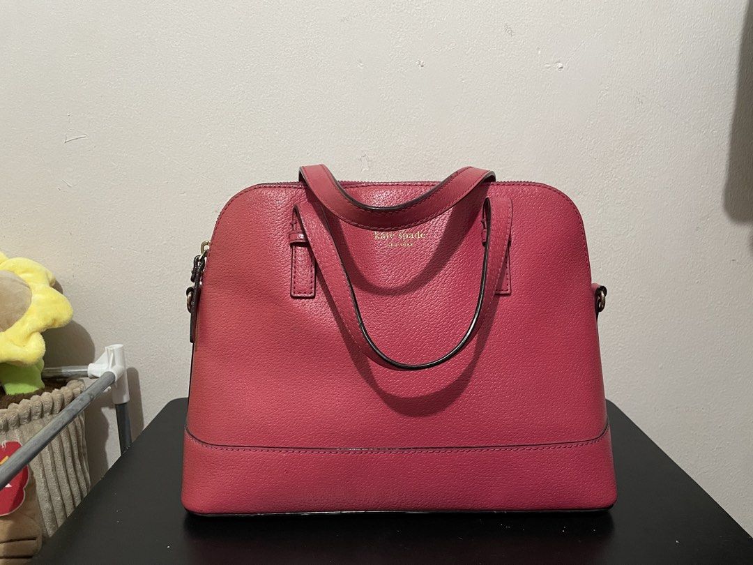 Kate Spade Pink Dome Satchel Handbag (Category: Luxury Bags & Wallets) located in Manila. Submitted by 6ollaa77 (Listing ID 1468773647, Image 1). Description: - Authentic Kate Spade dome satchel in vibrant bright pink pebble leather - Elegant gold foil logo stamped on the front - Double top handles with hardware attachments for an optional crossbody strap - Structured base panels to keep the bag standing upright easily - Secure zip top closure fo