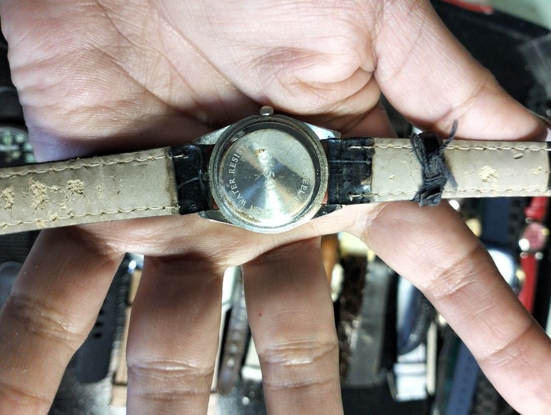 Kavini quartz watch with black leather strap (Category: Women's Watches) located in General Mariano Alvarez. Submitted by ma.miafajardo1219 (Listing ID 1468925181, Image 2). Description: - Brand/Model: Kavini Women's Watch - Movement: Reliable Quartz movement - Design: Silver-tone round case with a white dial and easy-to-read black numbers - Strap: Black faux leather strap (Note: visible peeling and wear along the underside and edges) - Closure: 