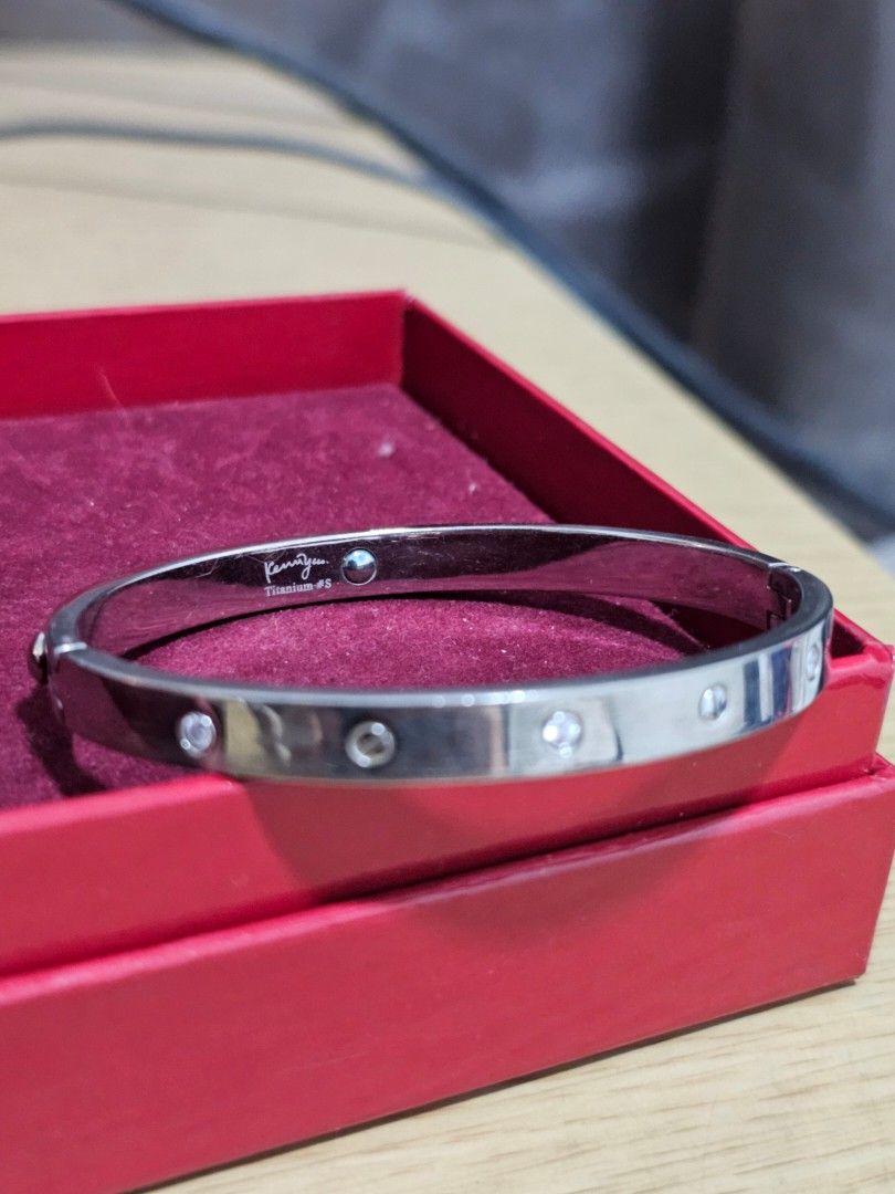 Kenny & Co. Titanium Bracelet Bangle with Rhinestones (Category: Bracelets) located in Caloocan City. Submitted by smart_shoppers_ville (Listing ID 1468712697, Image 3). Description: Silver-colored screw motif bangle from Kenny & co. Titanium #S. Embedded with sparkling rhinestones alternating with screw head details. Hinged design with a secure clasp mechanism. Stamped on the inner band. Includes a red presentation box lined with velvet. Sturdy 