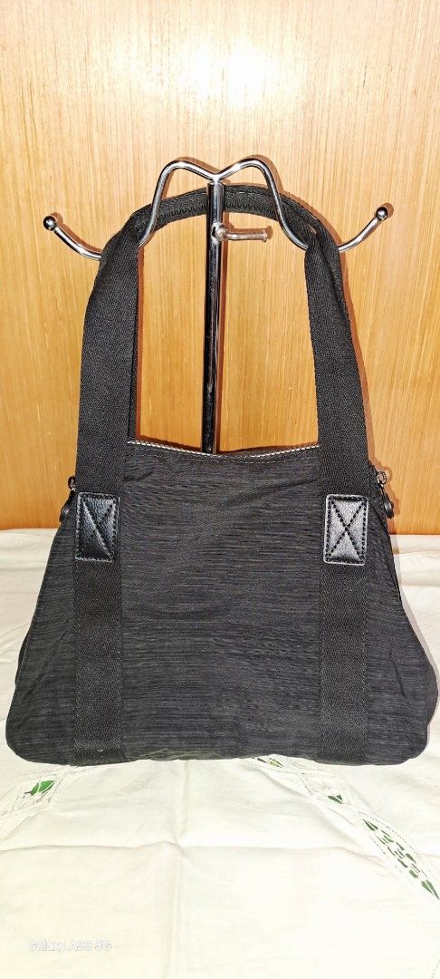 Kipling Black Nylon Tote Shoulder Bag with Strap (Category: Tote Bags) located in Baguio. Submitted by mng_assorted_baguio (Listing ID 1468787772, Image 2). Description: - Brand: Kipling - Material: Durable textured crinkle nylon in classic black - Carry options: Dual top handles and a detachable, adjustable shoulder strap - Pockets: Convenient front zip pocket with a spacious main compartment for daily essentials - Extras: Includes the iconic ro