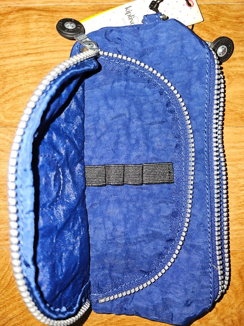 Kipling Blue Pouch Pencil Case (Category: Purses & Pouches) located in Quezon City. Submitted by findsbydavie (Listing ID 1468821695, Image 1). Description: - Brand: Kipling - Condition: Brand new with tags attached - Color: Deep blue with iconic round logo patch - Material: Durable textured nylon - Features: Multiple zippered compartments and built-in elastic pen holders - Details: Branded zipper pulls - Perfect for: Organizing stationery, makeu