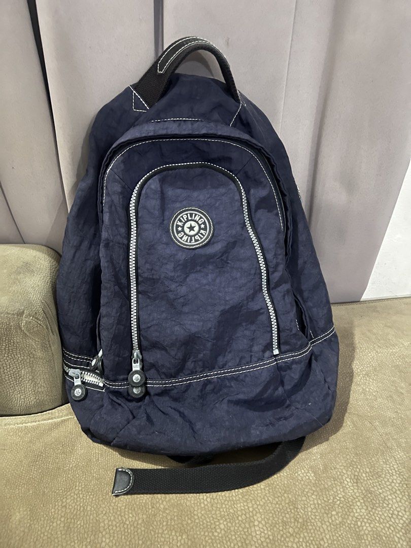 Kipling Navy Blue Nylon Backpack (Category: Backpacks) located in San Fernando. Submitted by WonderMamaonlineshop (Listing ID 1468891835, Image 1). Description: - Brand: Kipling - Material: Durable nylon in classic navy blue - Design: Round branded zipper pulls - Storage: Spacious main compartment and front pocket with double zippers - Comfort: Top grab handle and adjustable straps with embossed Kipling logo patch - Versatility: Perfect for daily
