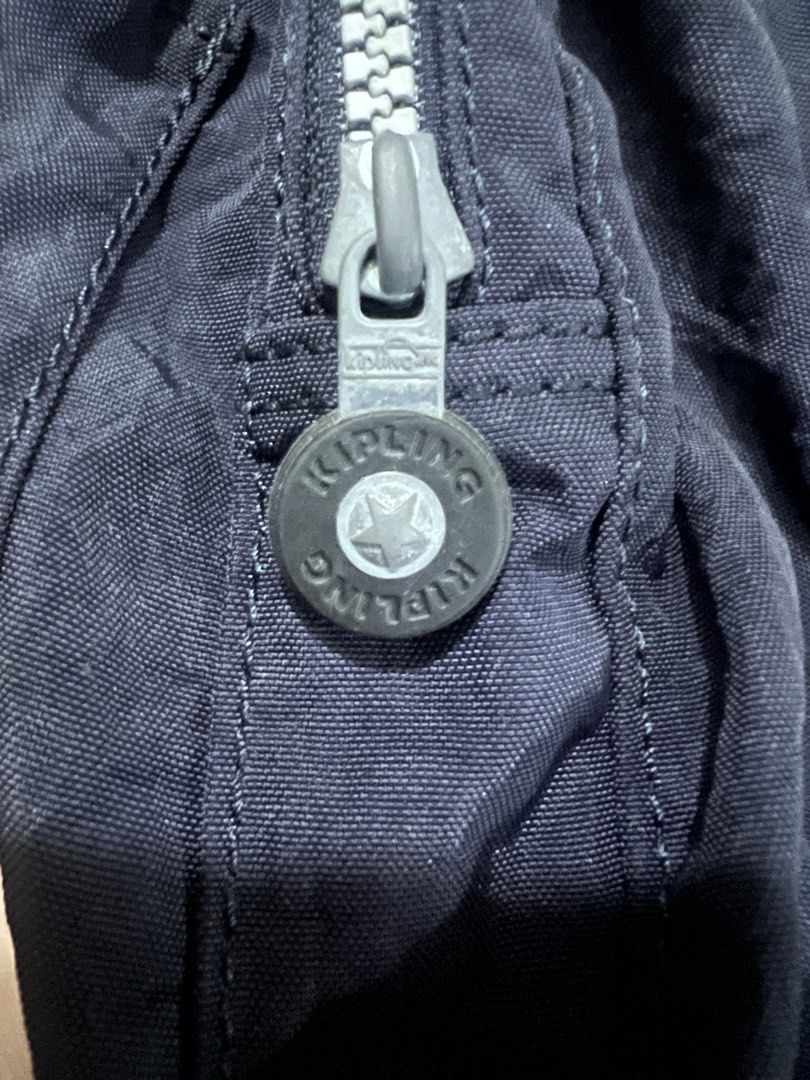 Kipling Navy Blue Nylon Backpack (Category: Backpacks) located in San Fernando. Submitted by WonderMamaonlineshop (Listing ID 1468892151, Image 3). Description: - Brand: Kipling - Color: Dark navy blue - Material: Nylon - Features: Front buckle, 2 front zip pockets with circular branded pull tabs, top handle, and adjustable shoulder straps - Condition: Excellent / Ready to use - Perfect for daily commute, school, or travel.