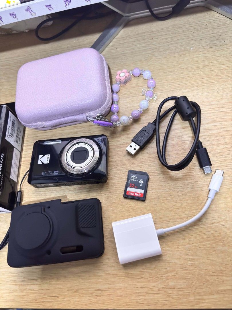 Kodak Pixpro FZ55 Digital Camera Bundle with Accessories (Category: Cameras) located in Mexico. Submitted by thototmal96618 (Listing ID 1468838248, Image 3). Description: - Model: Kodak Pixpro FZ55 Digital Camera (Black) - Condition: Complete set, ready to use - Includes: Original box and USB charging cable - Accessories: Black protective silicone case and pastel purple zippered storage case with beaded wrist strap - Storage & Transfer: 32GB SanD