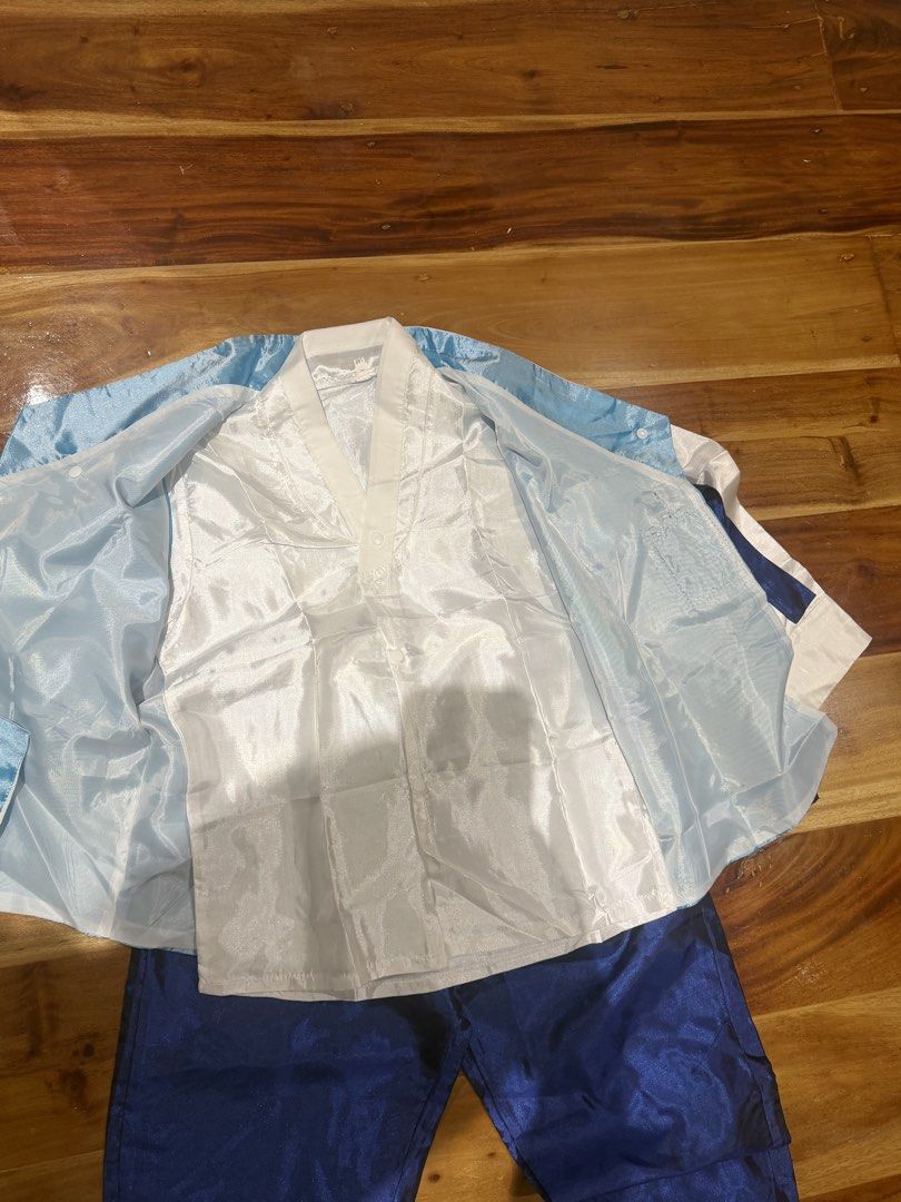 Korean Hanbok Set (Category: Babies & Kids Fashion) located in Quezon City. Submitted by twixietwix (Listing ID 1468875695, Image 2). Description: - Traditional Korean hanbok set for boys - Includes white long-sleeve jeogori shirt, light blue sleeveless vest with decorative sash, and dark blue trousers - Made of shiny, silky material - Perfect for cultural events, parties, and photoshoots - Only used once, like new.