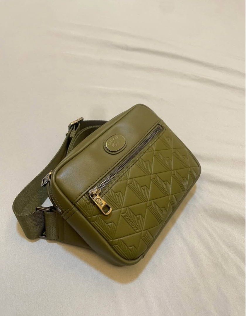 Lacoste Olive Green Crossbody Bag Monogram Pattern (Category: Cross-body Bags) located in Cebu City. Submitted by andrie_13 (Listing ID 1468783947, Image 3). Description: - Authentic green Lacoste crossbody bag in a stylish olive tone - Structured design with a textured geometric monogram front zipped pocket - Signature metal oval Lacoste logo badge near the top zipper - Durable and adjustable woven strap for a comfortable fit - Sleek dark hardwa