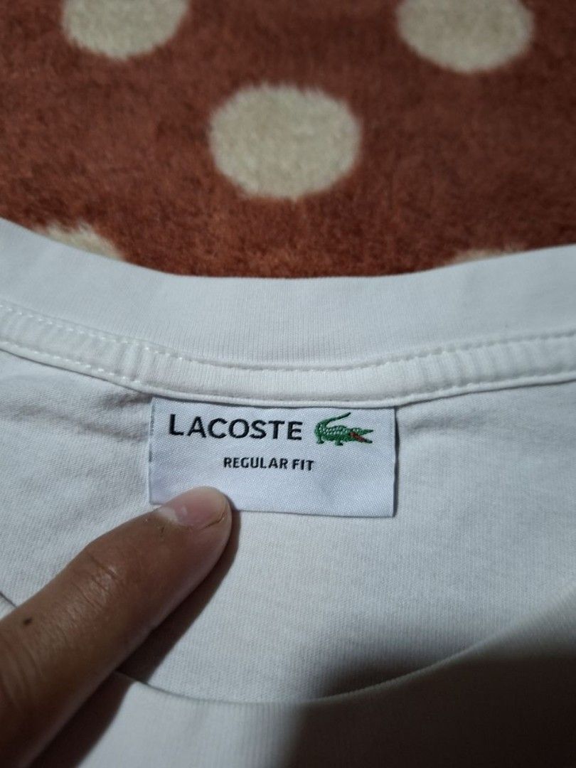 Lacoste Regular Fit White T-Shirt Size M (Category: Tshirts & Polo Shirts ) located in Rizal. Submitted by thrifthings_10 (Listing ID 1468879929, Image 2). Description: - Brand: Lacoste - Color: White - Size: Medium (Regular Fit) - Material: 100% Cotton - Design: Large blue LACOSTE chest graphic with crocodile logo - Details: Classic crew neck, short sleeves, interior tags intact - Condition: Great casual piece for everyday wear.