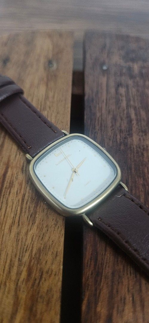 Lancel Quartz Watch with Brown Leather Strap (Category: Women's Watches) located in Santa Maria. Submitted by rommelmateo (Listing ID 1468860556, Image 2). Description: - Brand: Lancel - Movement: Battery-operated quartz - Case: Gold-tone square case with stainless steel back (Citizen movement base) - Dial: Clean white minimalist dial - Crown: Uniquely positioned on the left side - Strap: Brown leather strap - Condition: Vintage.