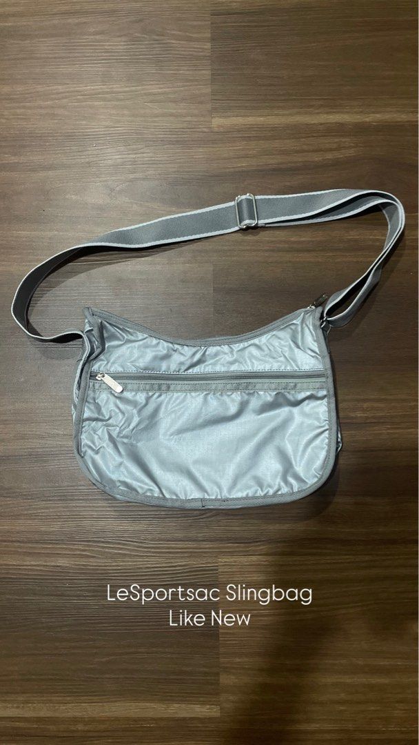 LeSportsac Grey Sling Bag (Category: Cross-body Bags) located in Bacolod City. Submitted by jmcercado (Listing ID 1468799546, Image 1). Description: - Brand: LeSportsac - Color: Classic Grey - Material: Lightweight, durable nylon - Strap: Long adjustable strap with silver metal slider - Pockets: Front zipper pocket with engraved metal pull tab - Design: Curved shape for a comfortable, stylish everyday carryall.