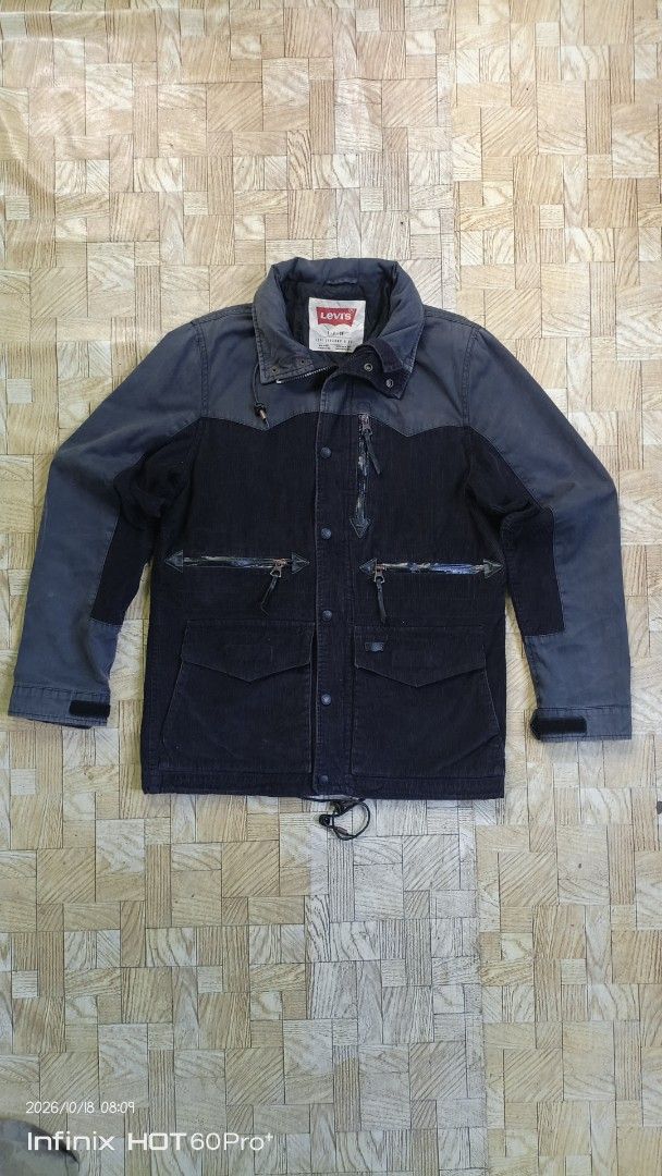 Levi's Corduroy Utility Jacket Grey Black (Category: Coats, Jackets and Outerwear) located in Candaba. Submitted by treblig. (Listing ID 1468713547, Image 1). Description: - Brand: Levi's - Material: Corduroy - Color: Grey and dark tones - Pockets: Multiple zippered front pockets - Details: Logo-stamped snap buttons, structured collar with inner red Levi's label - Fit & Adjustments: Adjustable drawstring hem and velcro cuffs.