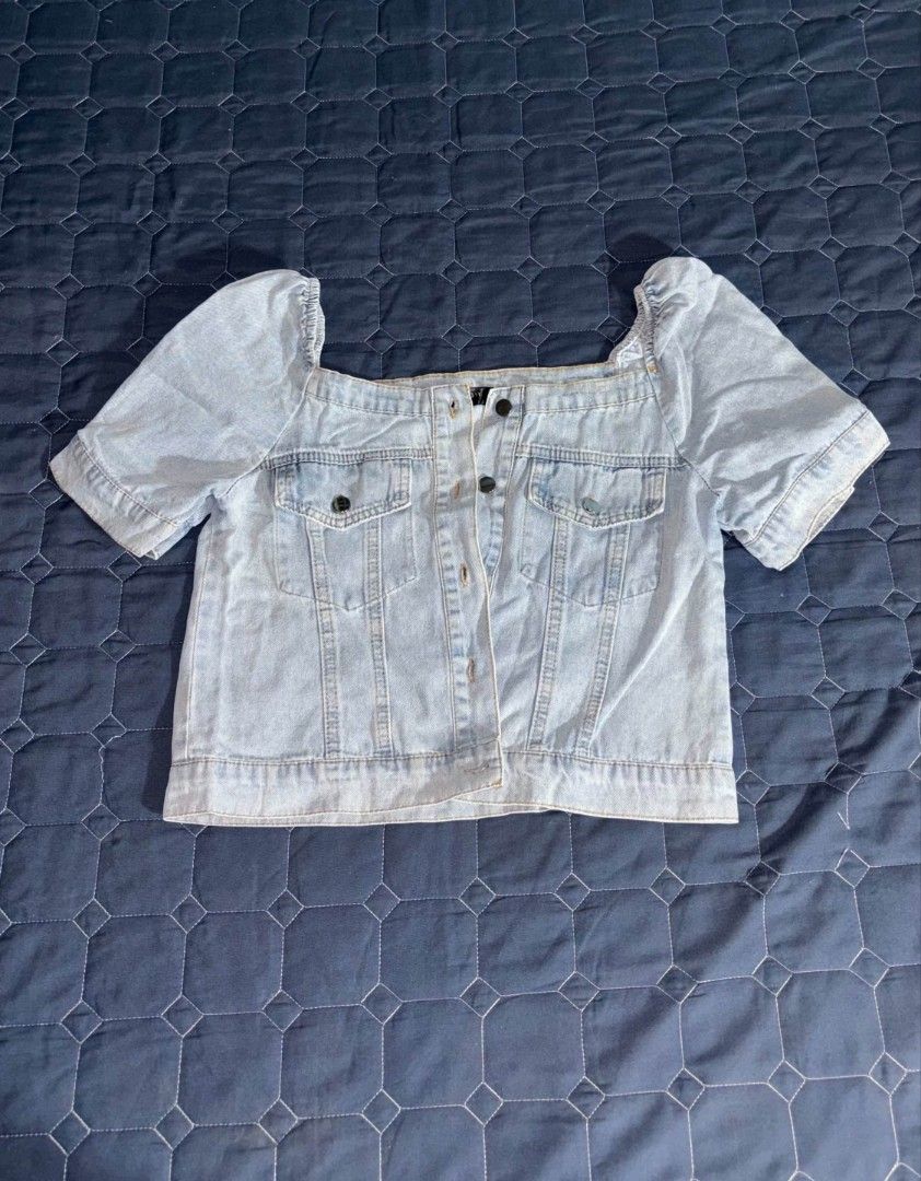 Light wash denim crop top with puff sleeves (Category: Blouses) located in Manila. Submitted by itz_zy (Listing ID 1468852965, Image 1). Description: - Style: Casual cropped light wash denim top - Details: Square neckline, short puff sleeves, button-up front, two button-flap chest pockets - Fit: Cropped length, perfect for pairing with high-waisted bottoms - Condition: Excellent, clean fabric with no stains or loose threads.