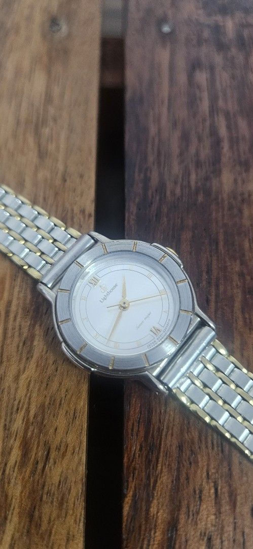 Lighthouse Two-Tone Analog Watch With Roman Numerals (Category: Women's Watches) located in Santa Maria. Submitted by rommelmateo (Listing ID 1468860512, Image 2). Description: - Brand: Lighthouse - Movement: Battery-operated quartz movement for reliable timekeeping - Design: Two-tone silver and gold strap with mixed metal aesthetic - Dial: Textured silver dial featuring Roman numerals at twelve and six - Bezel: Round bezel accented with metallic