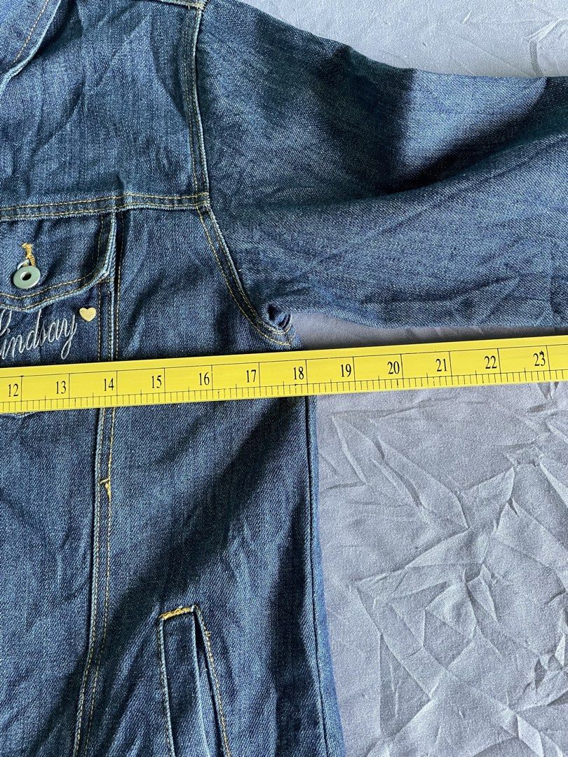 Lindsay Original Authentic Clothing Denim Jacket (Category: Coats, Jackets and Outerwear) located in Cagayan de Oro. Submitted by jekdels05 (Listing ID 1468767381, Image 2). Description: - Brand: Lindsay - Wash: Classic dark wash denim - Details: Contrast stitching with "Lindsay" embroidery and tiny heart on the left chest pocket - Pockets: Button-up front, button-flap chest pockets, and side pockets - Measurements: Width ~21 inches, Length ~24 i